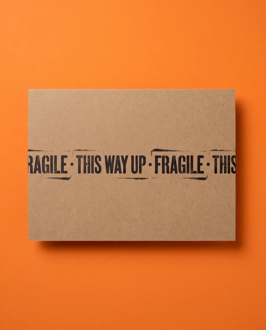 Kraft proof card on orange: Fragile, this way up, repeating on a single 14 mm line, printed with a Rolly L