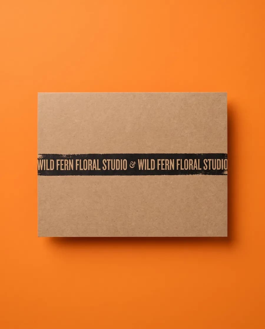Kraft proof card on orange: Wild Fern Floral Studio, an inverted single 14 mm line, printed with a Rolly L