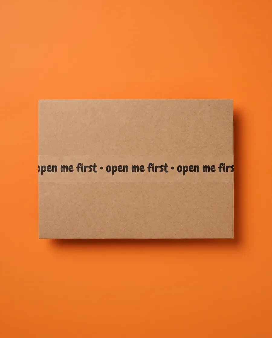 Kraft proof card on orange: open me first repeating on a single 14 mm line, printed with a Rolly L