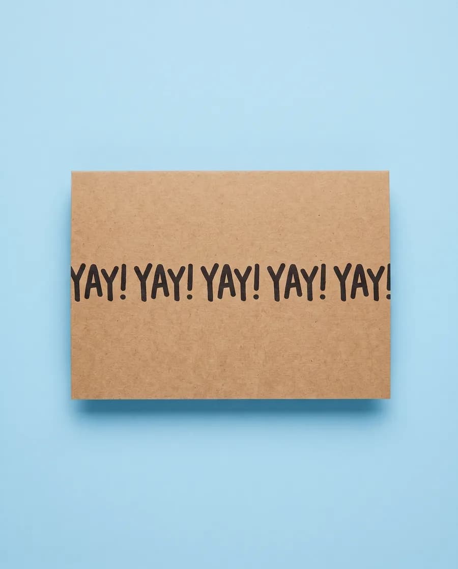 Kraft proof card on light blue: YAY! repeating on a single 14 mm line, printed with a Rolly M