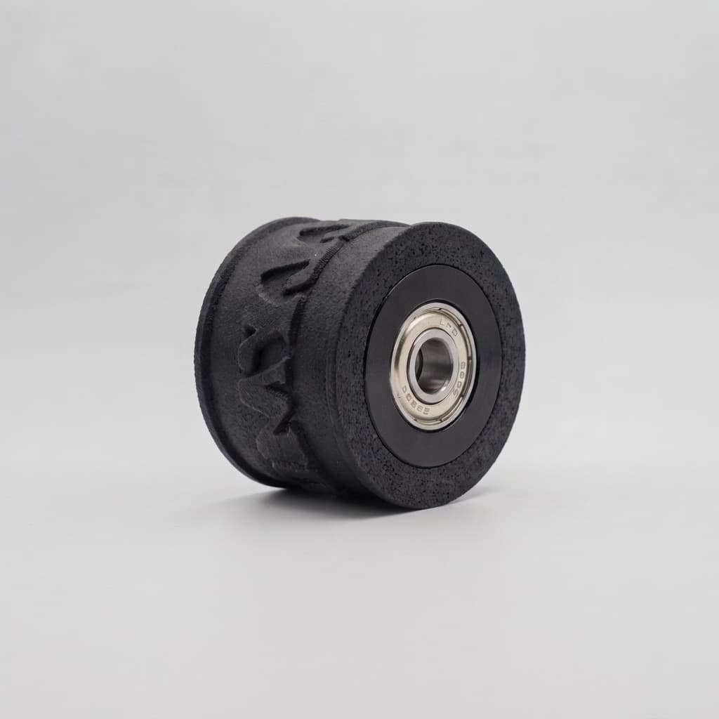 A black roll with raised engraved lettering and a steel bearing in its centre